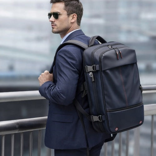 Homme en costume portant un sac à dos compression sous vide AirVault, accessoire voyage professionnel