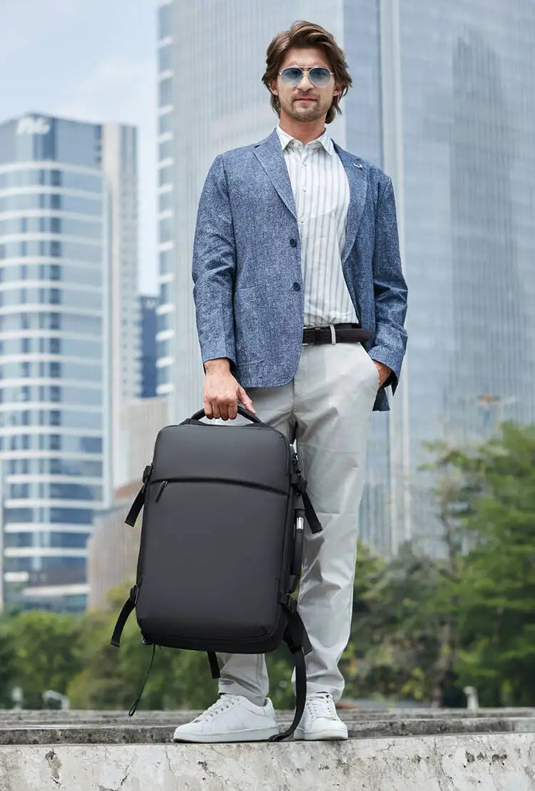 Homme élégant tenant un sac à dos compression sous vide, voyage urbain, accessoire bagage cabine