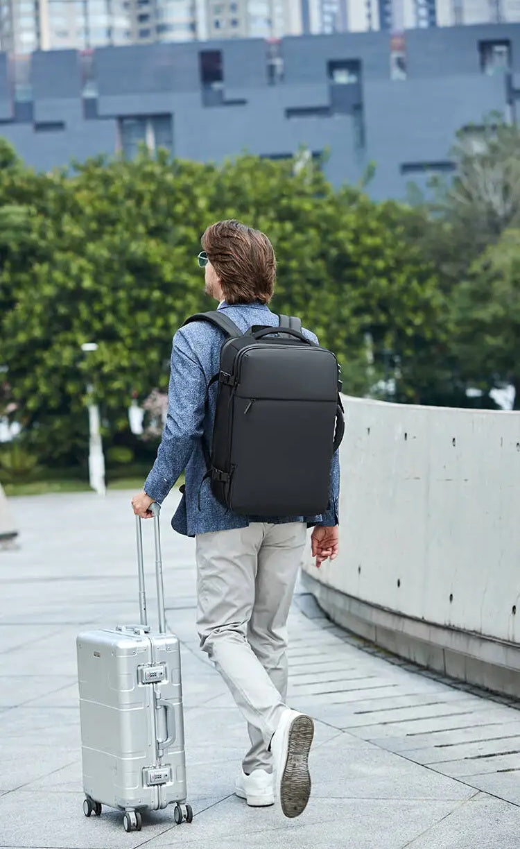 Homme avec sac à dos compression sous vide et valise cabine, accessoire voyage pratique