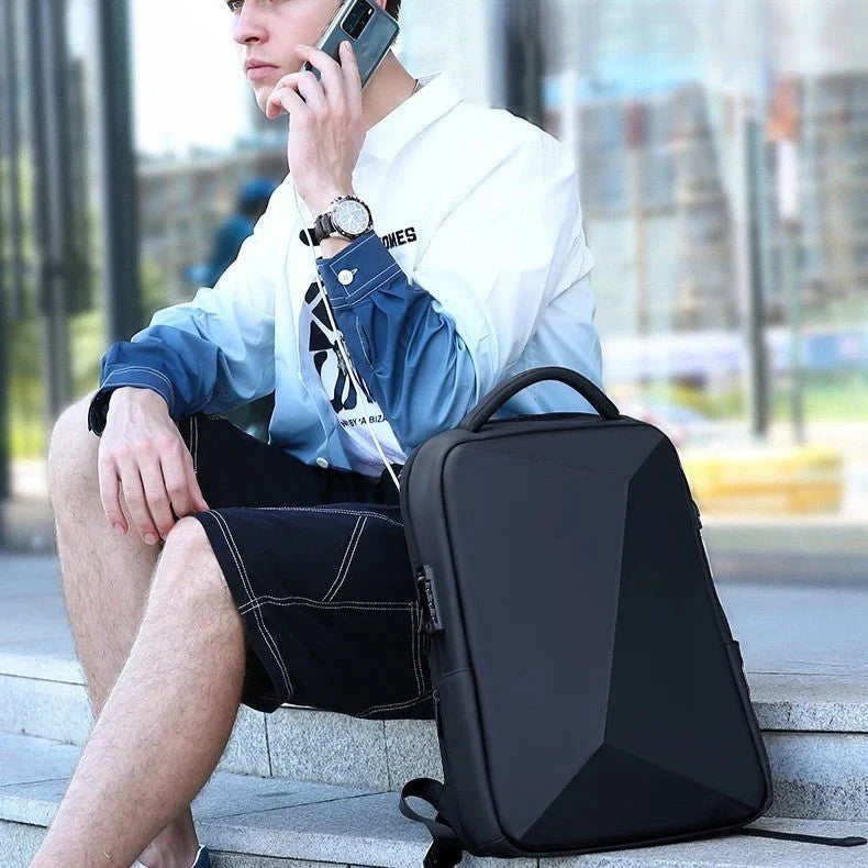 Homme utilisant le sac-a-dos-antivol-nomad-shield, dos noir extensible avec sangle pour valise et port USB, dans un aéroport.
