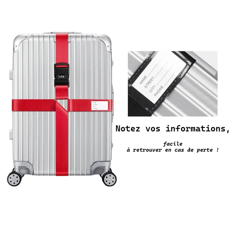Sangle pour valise croisée antivol à code fixée sur une valise rigide argent, utilisée en situation réelle dans un aéroport, avec poignée télescopique tirée par un voyageur. etiquette identification integrés