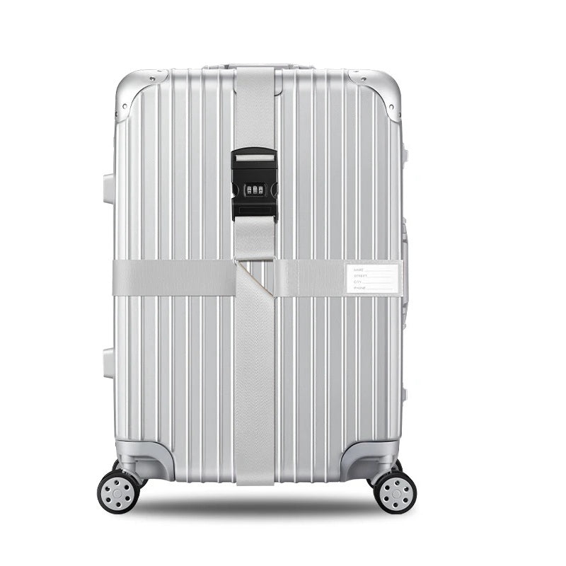 Sangle pour valise croisée antivol à code fixée sur une valise rigide argent, utilisée en situation réelle dans un aéroport, avec poignée télescopique tirée par un voyageur. gris