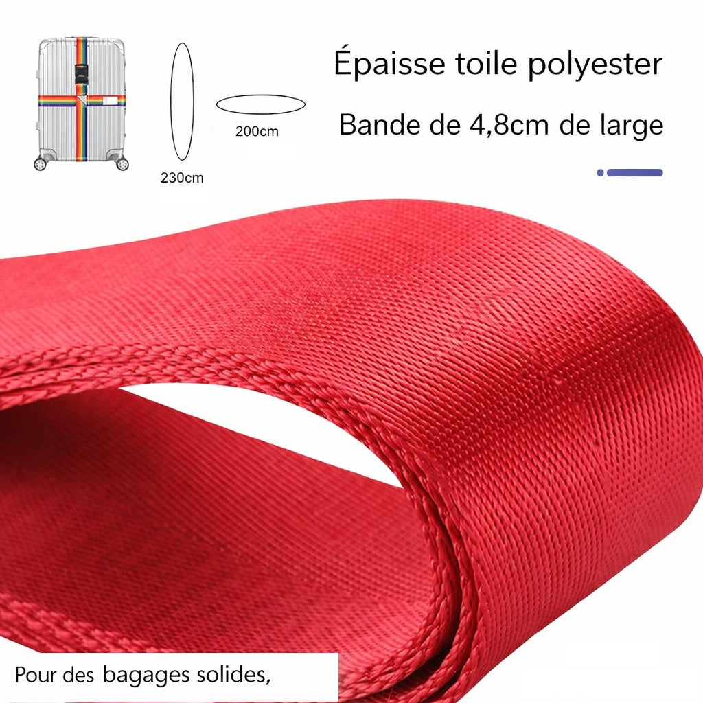 Sangle pour valise croisée antivol à code fixée sur une valise rigide argent, utilisée en situation réelle dans un aéroport, avec poignée télescopique tirée par un voyageur. Robuste