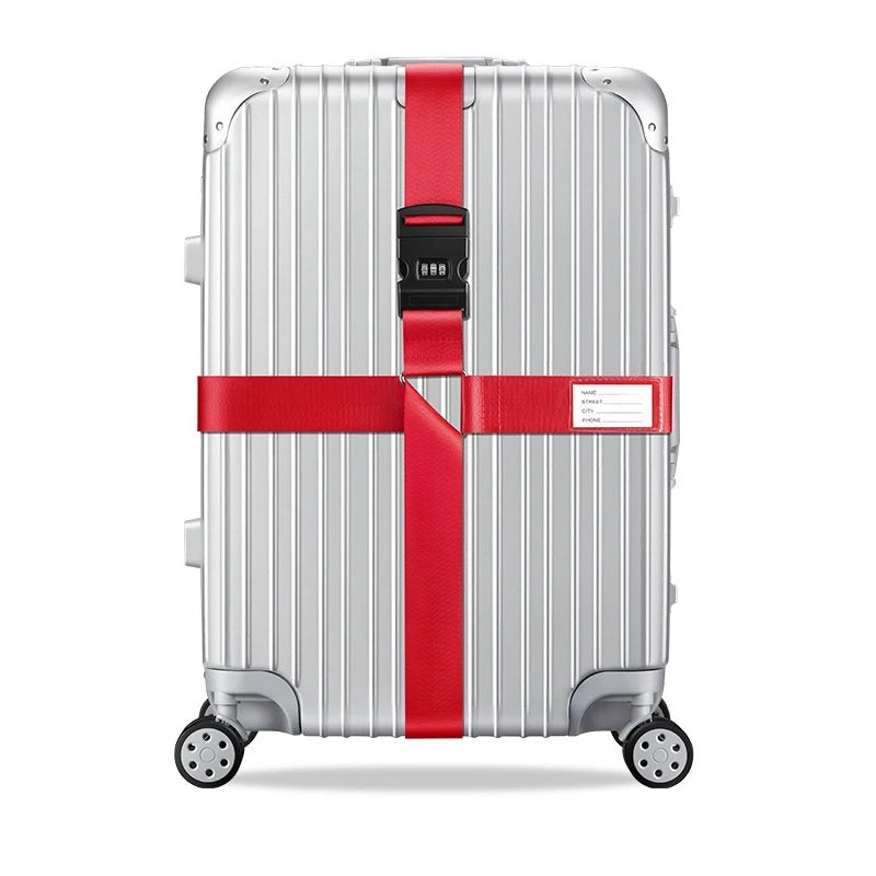 Sangle pour valise croisée antivol à code fixée sur une valise rigide argent, utilisée en situation réelle dans un aéroport, avec poignée télescopique tirée par un voyageur. rouge