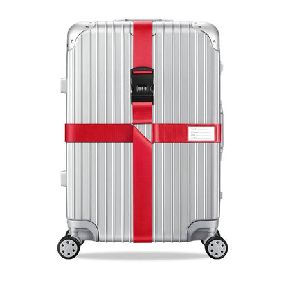Sangle pour valise croisée antivol à code fixée sur une valise rigide argent, utilisée en situation réelle dans un aéroport, avec poignée télescopique tirée par un voyageur. rouge