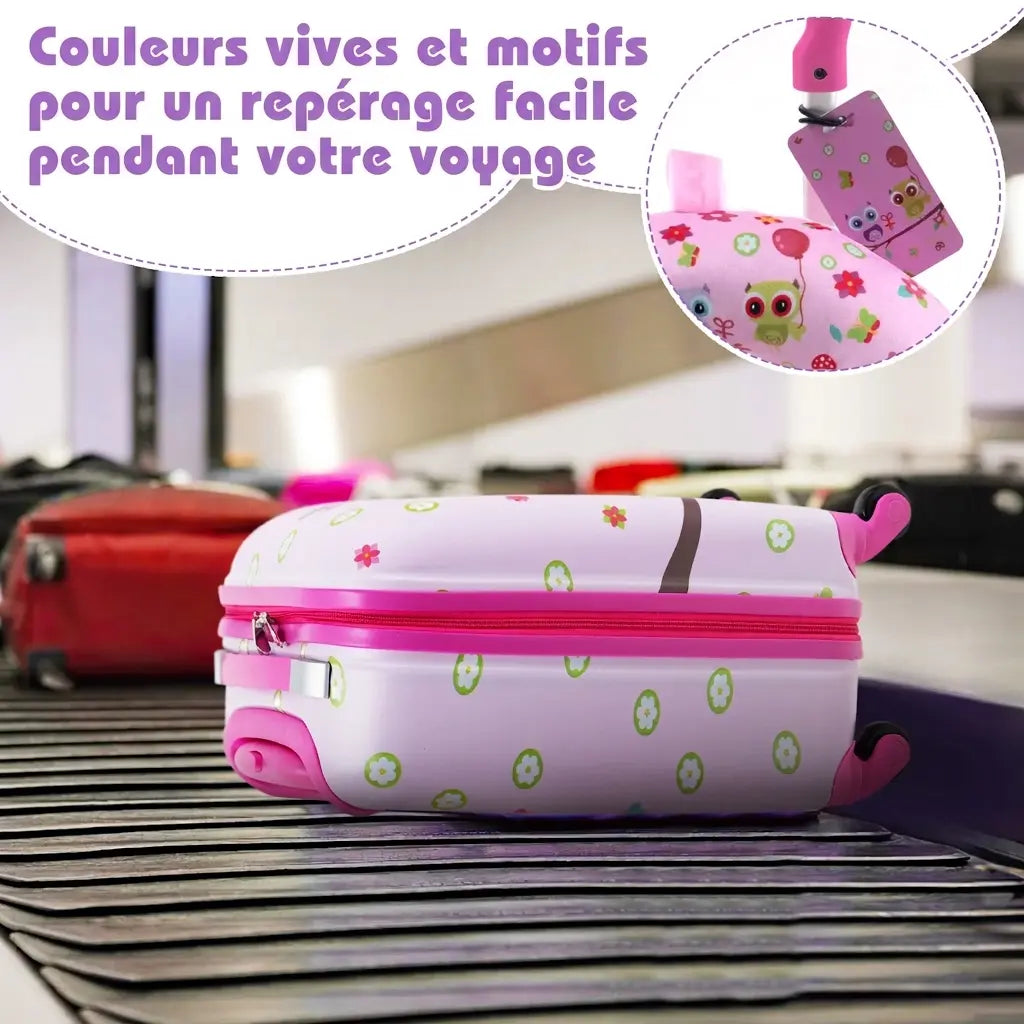 Valise enfant rose sur un tapis à bagages, détail de l’étiquette à motifs chouettes