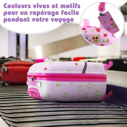 Valise enfant rose sur un tapis à bagages, détail de l’étiquette à motifs chouettes